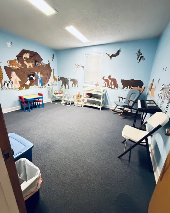 Church childcare room with a painted Noah's ark mural, small tables and clean carpet